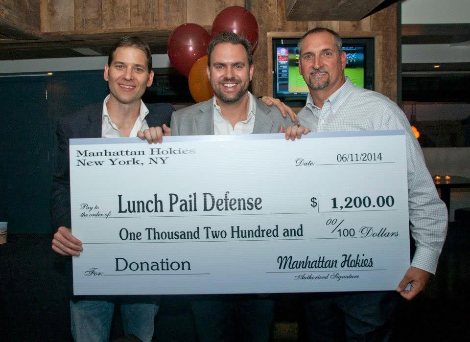 Three attendees holding a Manhattan Hokies donation check at a 2014 chapter event